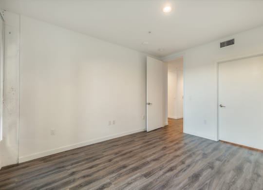 a living room with white walls and wood floors