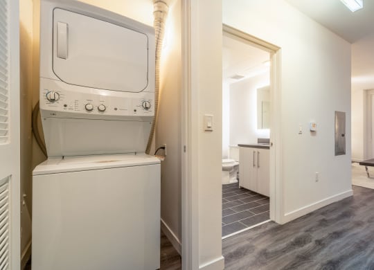 a laundry room with a washer and dryer and a door to a bathroom