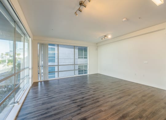 an empty living room with a large window and a balcony