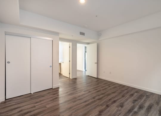 an empty living room with white walls and wood flooring