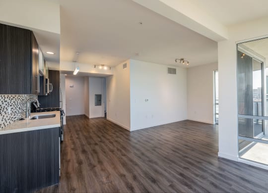 a kitchen and living room with wood flooring and a large window