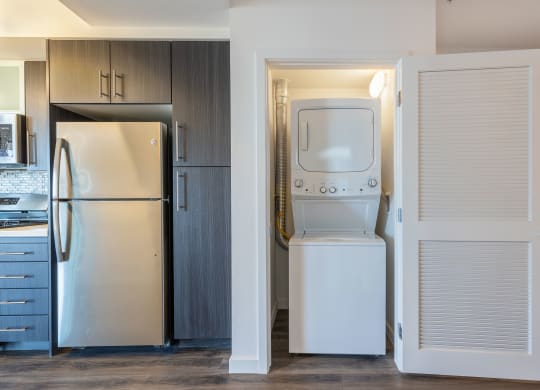 a kitchen with a washer and dryer and a refrigerator