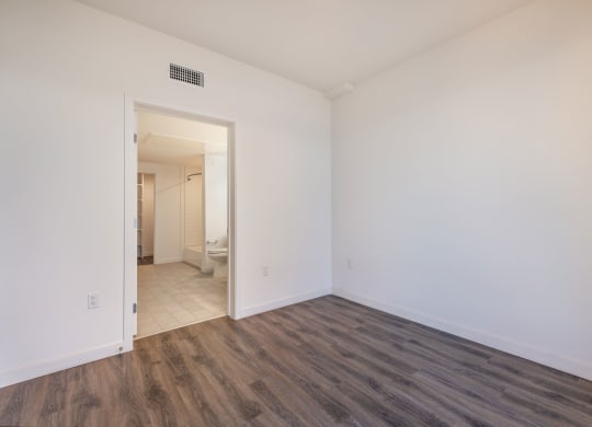 an empty living room with white walls and wood flooring