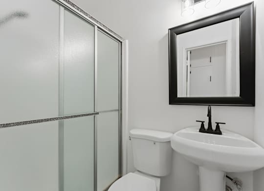 A white toilet sits next to a sink in a bathroom.