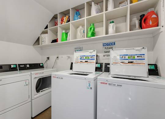 A laundry room with a washer and dryer and a shelf with cleaning supplies.