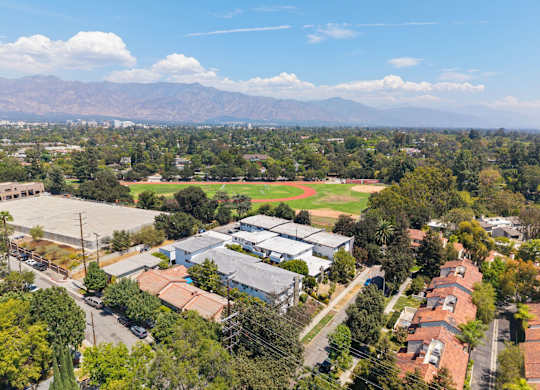 A view of a residential area with houses and a large open field.