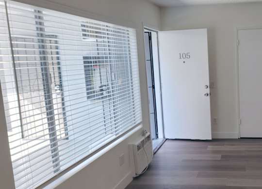 A room with a door marked 105 and a window with blinds.