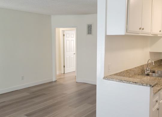 A kitchen with a granite countertop and white cabinets.