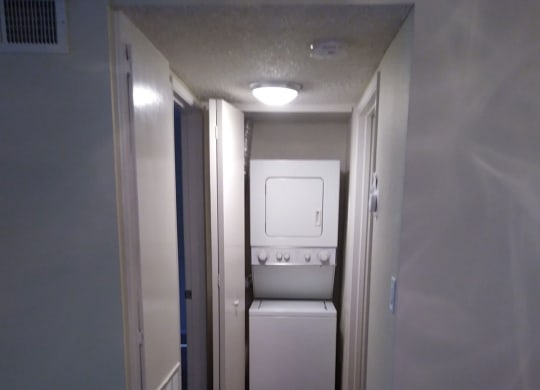 In-unit stacked washer and dryer in apartment at Teton Pines Apartments in Escondido, California.