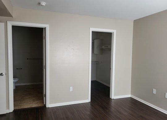 Master bedroom with bathroom, large walk-in closet and plank style flooring at The Cove at Bear Valley in Escondido, California.