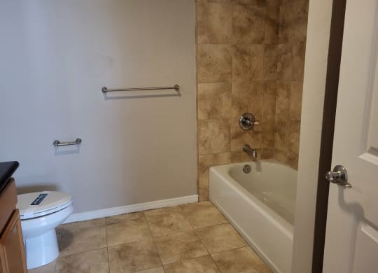 Bathroom with beautiful tiling and white fixtures at The Cove at Bear Valley in Escondido, California.