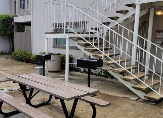 Picnic table and barbeque in courtyard at Lakeshore Terrace Apartments in Lakeside, California.