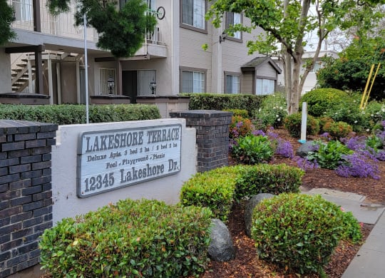 Front monument sign and beautiful gardens in front of Lakeshore Terrace Apartments in Lakeside, California.