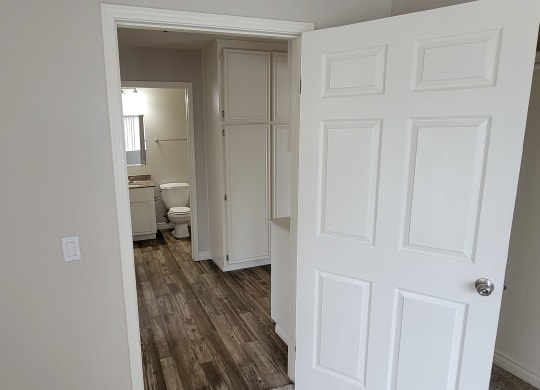 Bedroom view of hallway with linen closets and bathroom at Lakeshore Terrace Apartments in Lakeside, California.