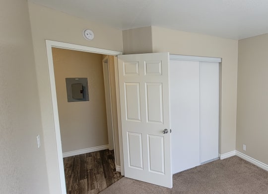 Carpeted bedroom with large closets at Lakeshore Terrace Apartments in Lakeside, California.
