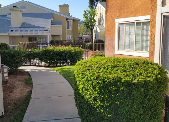 Walkway between buildings around the swimming pool at The Cove at Bear Valley Apartments in Escondido, California.