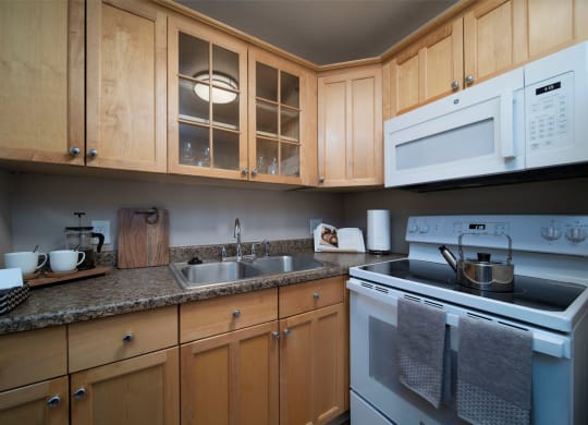 Beautiful kitchen cabinets and granite countertops at the Atrium Apartments in San Diego, California.