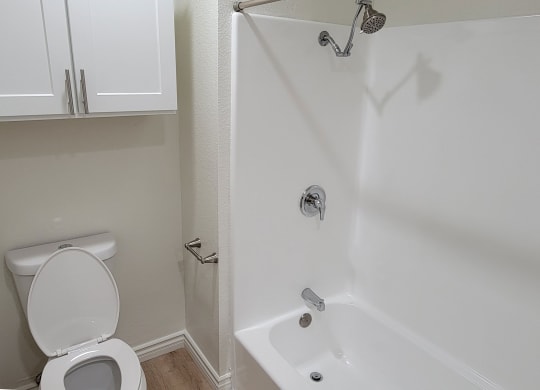 Bathroom with white fixtures and cabinets in one bedroom apartment at the Atrium Apartments in San Diego, CA.