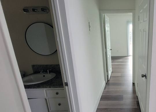 A bathroom with a sink and mirror is visible.