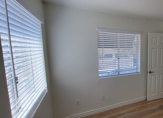 Bedroom with lots of natural light and large closets in one bedroom apartment at the Atrium Apartments in San Diego.