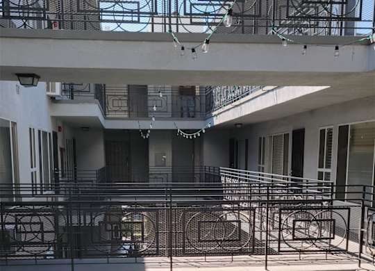 A courtyard with a metal railing and a planter box.