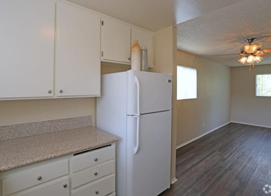 Open kitchen with white cabinets and appliances at Villa Pacific Apartments in Oceanside, California.