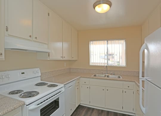 Kitchen with spacious white cabinets and white appliances at Villa Pacific Apartments in Oceanside, California.