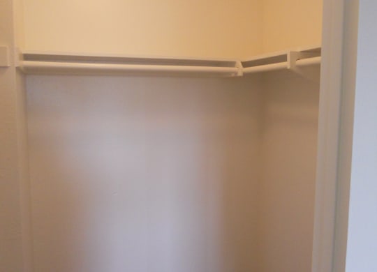 Walk-in closet in carpeted bedroom at Villa Pacific Apartments in Oceanside, California.
