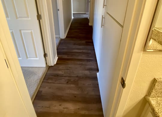Looking from bathroom down bedroom hallway with built-in cabinets at Villa Pacific Apartments in Oceanside, California.