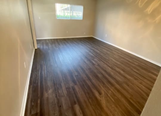 Plank style flooring in living room and dining area with ceiling fan at Villa Pacific Apartments in Oceanside, California.