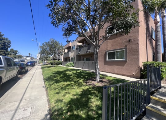 Sidewalk view of apartment buildings at Villa Pacific Apartments in Oceanside, California.