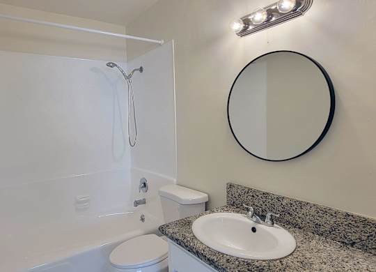 A bathroom with a white tub, toilet, and sink.