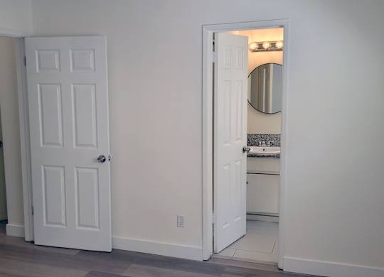 A white door is open to a bathroom.
