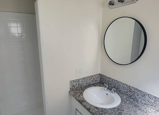 A bathroom with a sink and mirror.