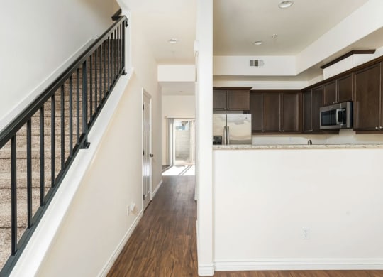 Front entrance view of kitchen and hallway to living room and sliding glass doors to private porch at The Nines Townhomes in Escondido, California.