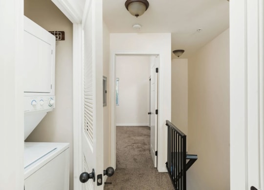 Full size stacked washer and dryer in bedroom hallway at The Nines Townhomes in Escondido, California.