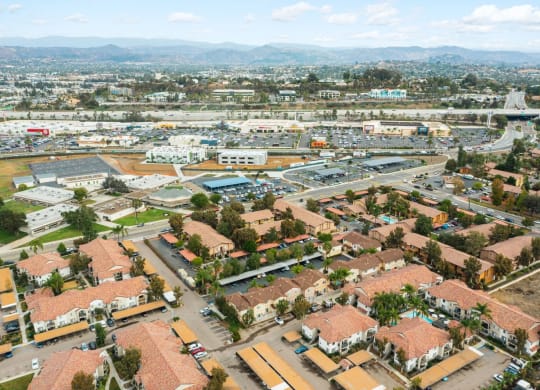 Aerial view of neighborhoods and shopping centers around The Nines Townhomes in Escondido, California.