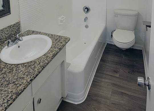A bathroom with a sink, toilet, and bathtub.