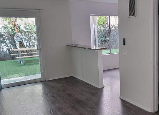 A room with a sliding glass door leading to a backyard.