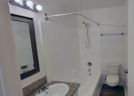 A bathroom with a toilet, sink, and shower.