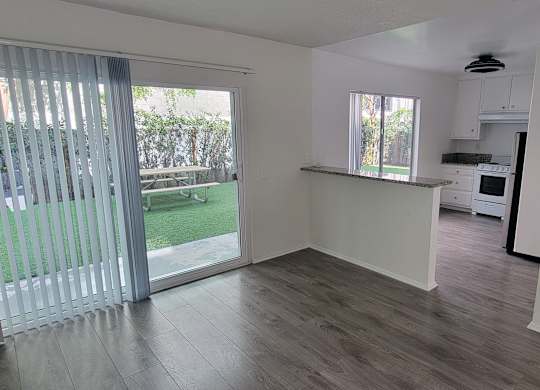 A room with a sliding glass door leading to a backyard.