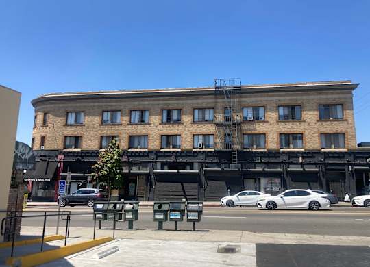 Street view of the brick building with studio apartments at The Western at Rosewood in Los Angeles, California.