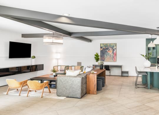 a living and dining area with a dining table and chairs and a kitchen in the background