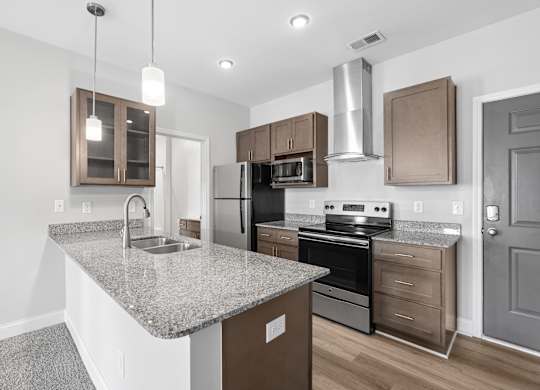 A kitchen with granite countertops and stainless steel appliances.