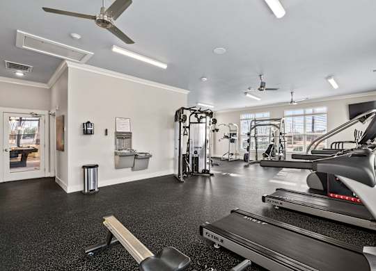 A gym with treadmills, weights, and exercise equipment.