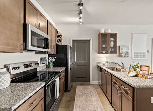 A kitchen with brown cabinets and a black refrigerator.