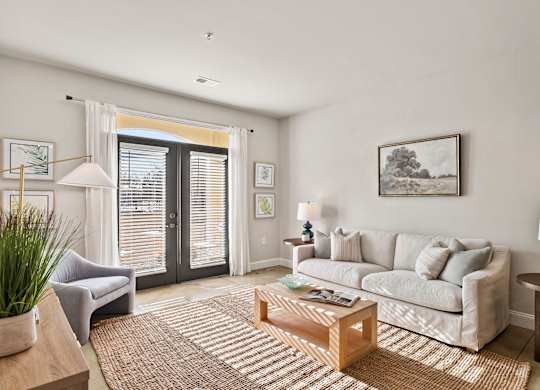 A living room with a grey couch, a coffee table, and a painting on the wall.