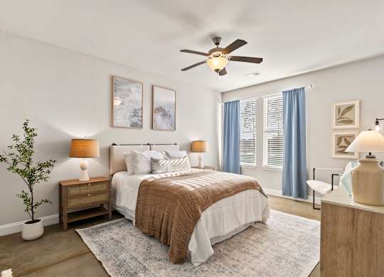 A bedroom with a bed, nightstands, and a ceiling fan.