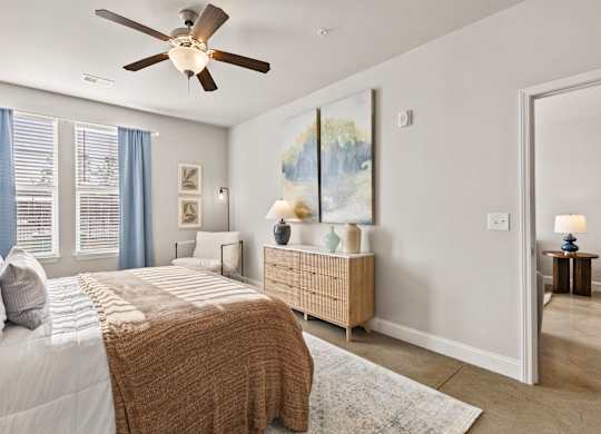 A bedroom with a large bed and a ceiling fan.