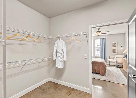A white bathroom with a white robe hanging on a hanger.